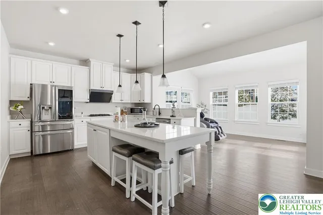 a dining room with wooden floor a chandelier a glass table and chairs