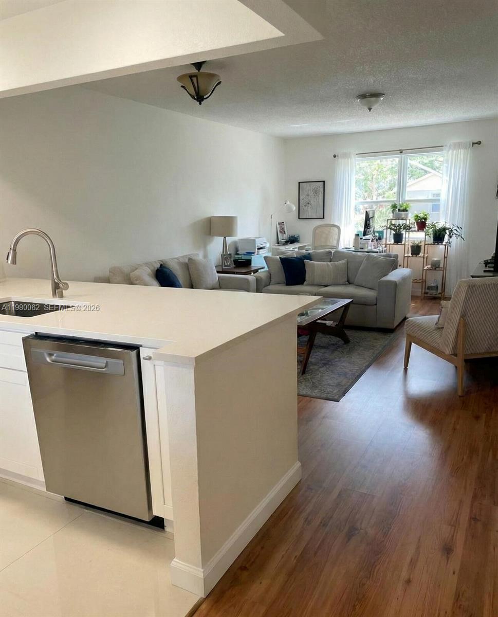 100 Ashbury Road, Unit 305 Hollywood, FL 33024 - Photo 4 of 8 a living room with furniture a wooden floor and a sink