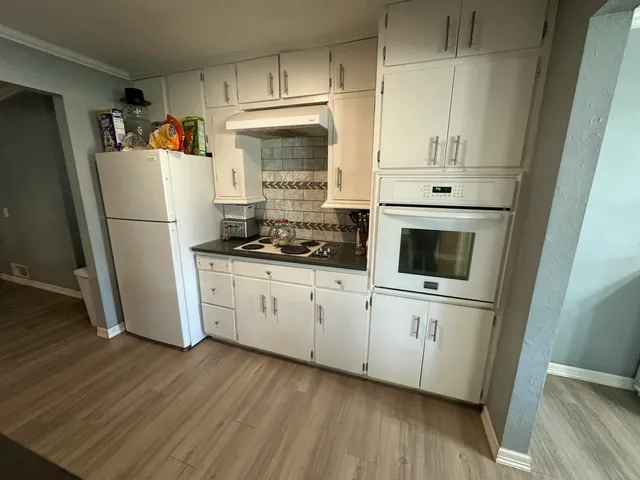 a kitchen with white cabinets and white appliances