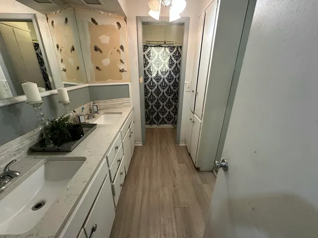 a bathroom with double vanity sink and mirror