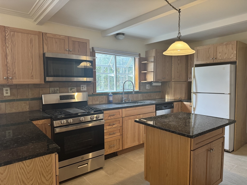a kitchen with stainless steel appliances granite countertop a sink stove and refrigerator