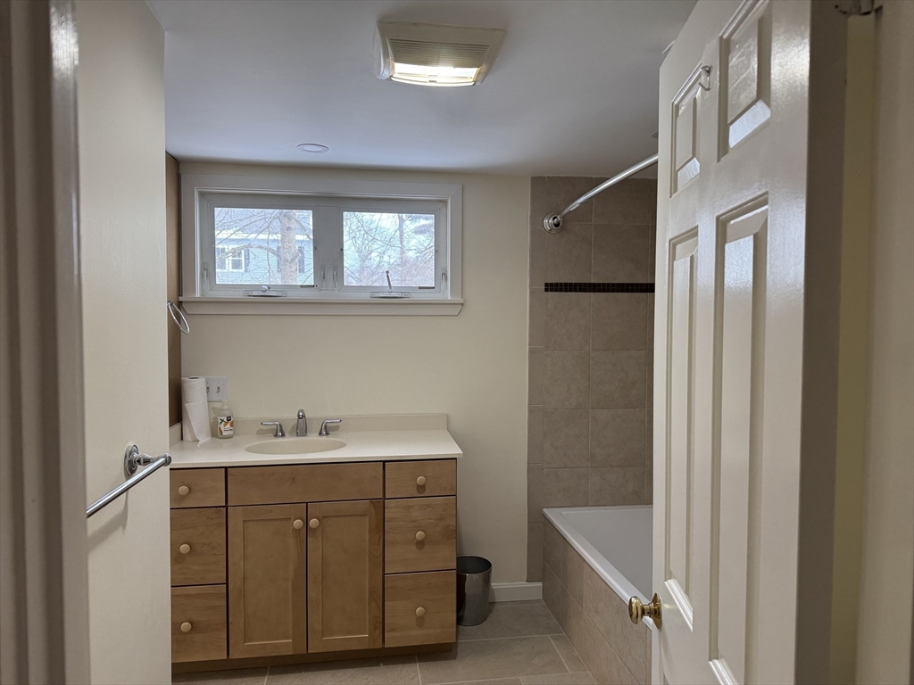 351 Village Street, Unit FIRST Millis, MA 02054 - Photo 5 of 9 a bathroom with a sink mirror and a bathtub