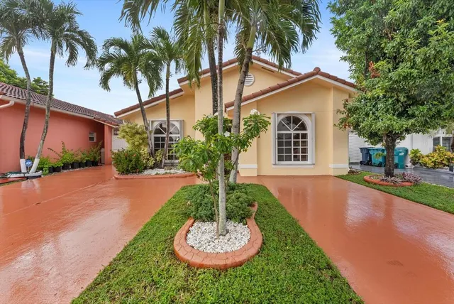 a front view of a house with a yard and potted plants