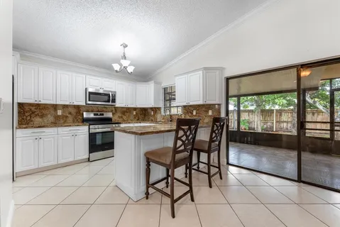 a kitchen with a granite countertop cabinets a sink and appliances