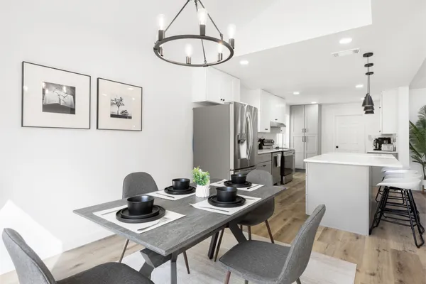 a kitchen with stainless steel appliances a dining table and chairs