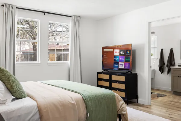 a bedroom with a bed and a flat screen tv