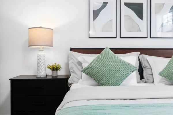 a bed sitting in a bedroom next to a window