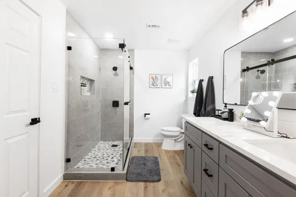 a bathroom with a sink a toilet and shower