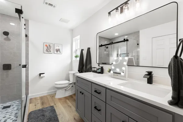 a bathroom with a sink a toilet and a mirror