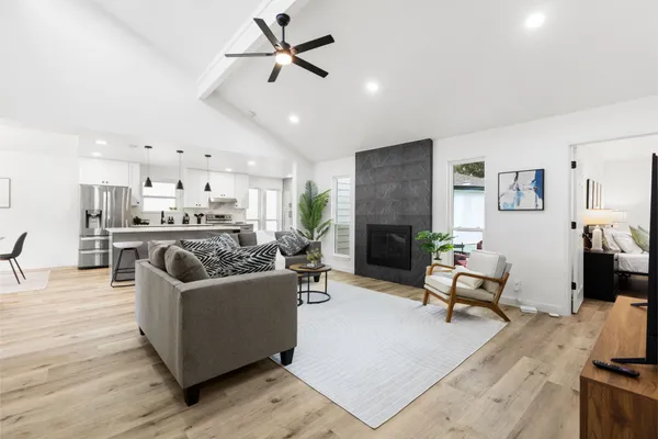 a living room with furniture kitchen view and a fireplace