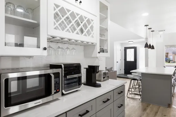 a kitchen with stainless steel appliances a stove and white cabinets