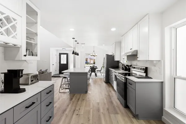 a kitchen with stainless steel appliances a stove top oven a sink dishwasher and a refrigerator