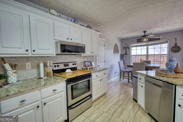 a kitchen with granite countertop a stove sink and cabinets