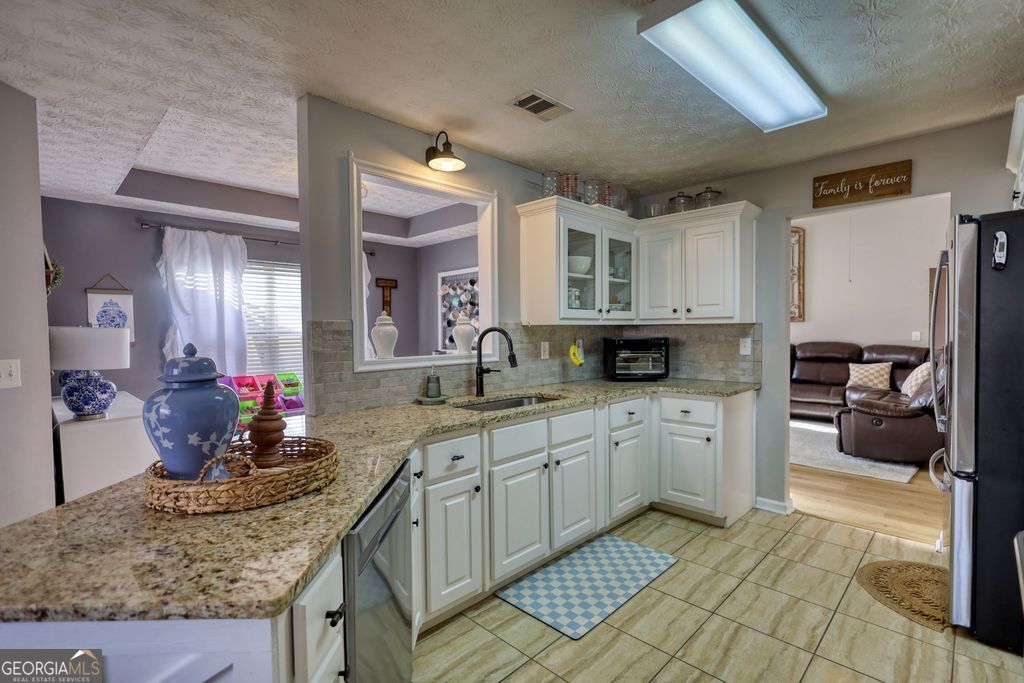 4610 Atlanta Highway Rutledge, GA 30663 - Photo 13 of 32 a kitchen with stainless steel appliances granite countertop a sink and cabinets