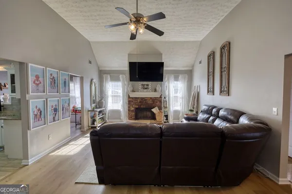 a living room with furniture a flat screen tv and a fireplace