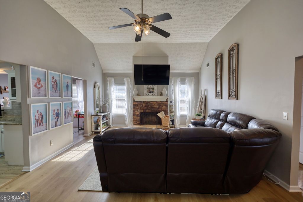 4610 Atlanta Highway Rutledge, GA 30663 - Photo 2 of 32 a living room with furniture a flat screen tv and a fireplace