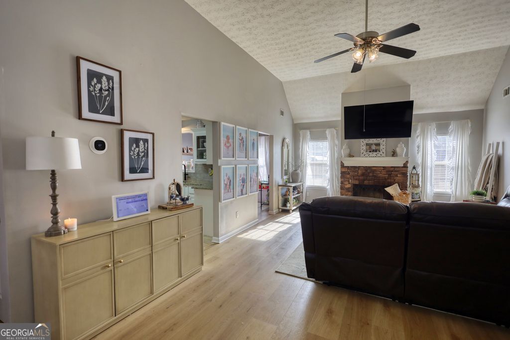 4610 Atlanta Highway Rutledge, GA 30663 - Photo 3 of 32 a living room with furniture a flat screen tv and a fireplace