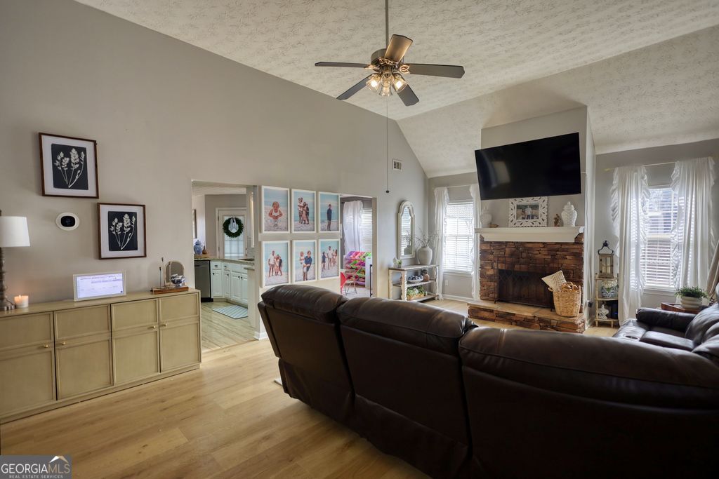 4610 Atlanta Highway Rutledge, GA 30663 - Photo 4 of 32 a living room with furniture a flat screen tv and a fireplace