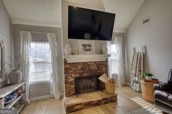 a living room with furniture a flat screen tv and a fireplace