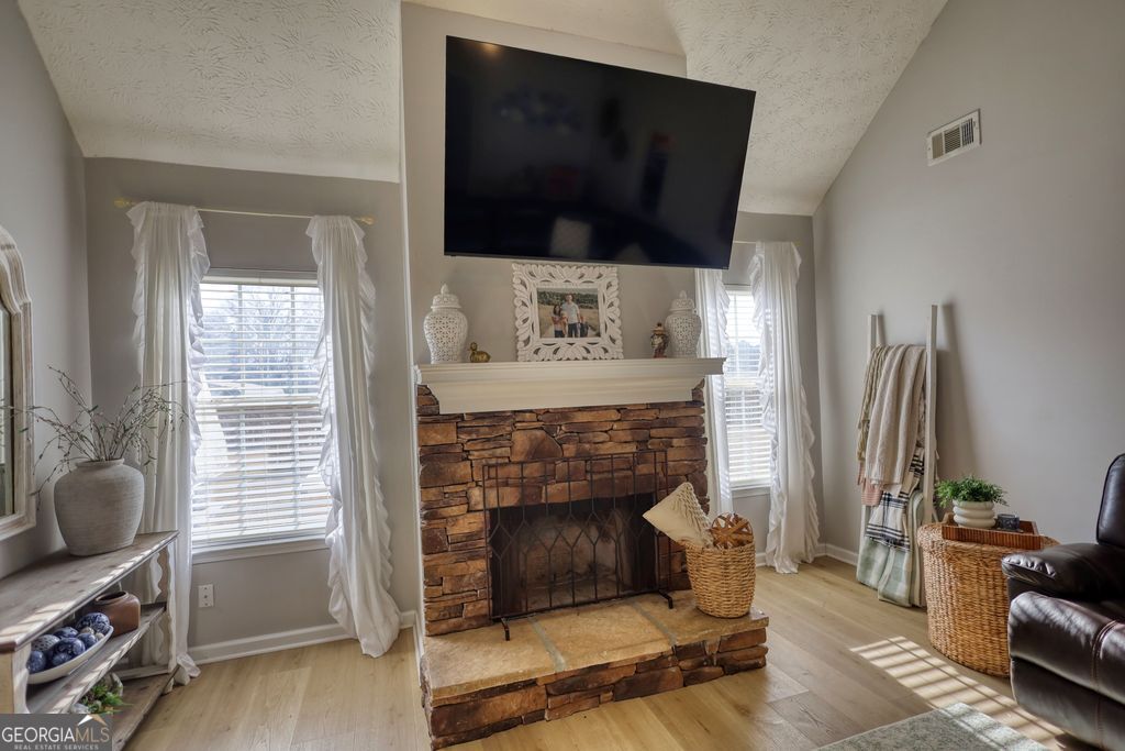 4610 Atlanta Highway Rutledge, GA 30663 - Photo 6 of 32 a living room with furniture a flat screen tv and a fireplace