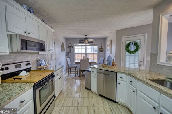 a kitchen with stove a sink and cabinets