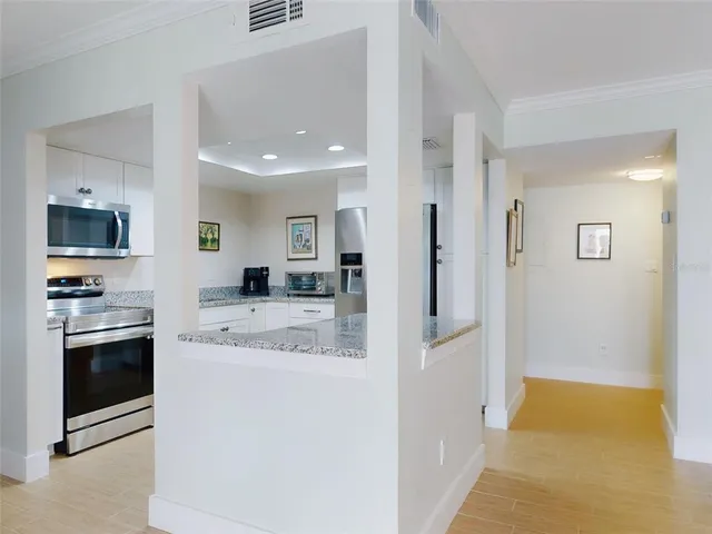 a kitchen with stainless steel appliances granite countertop a refrigerator and a stove