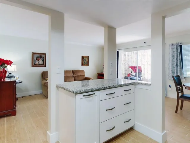 a living room with granite countertop furniture and a flat screen tv