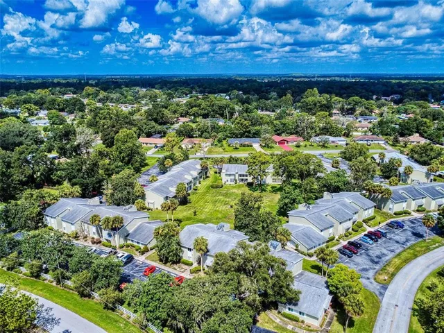 an aerial view of a house with a yard and outdoor seating