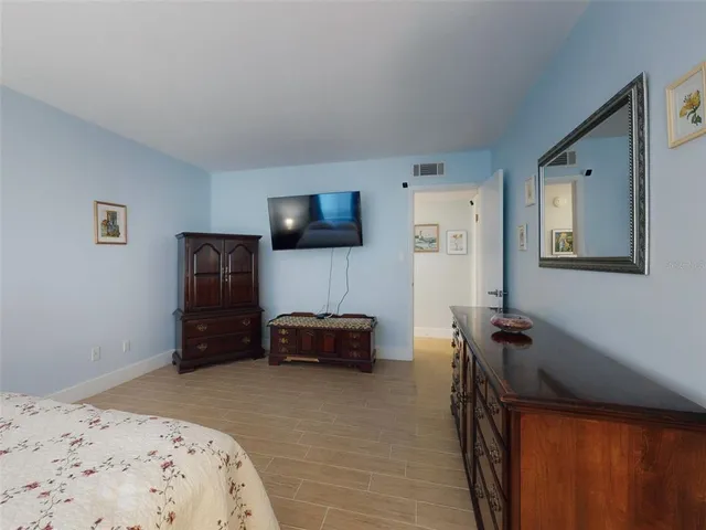 a bedroom with a bed and a tv on dresser