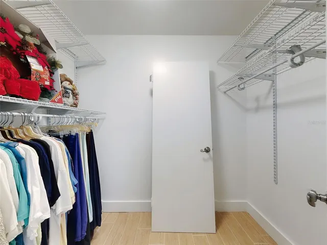 a view of walk in closet with clothes and shoes