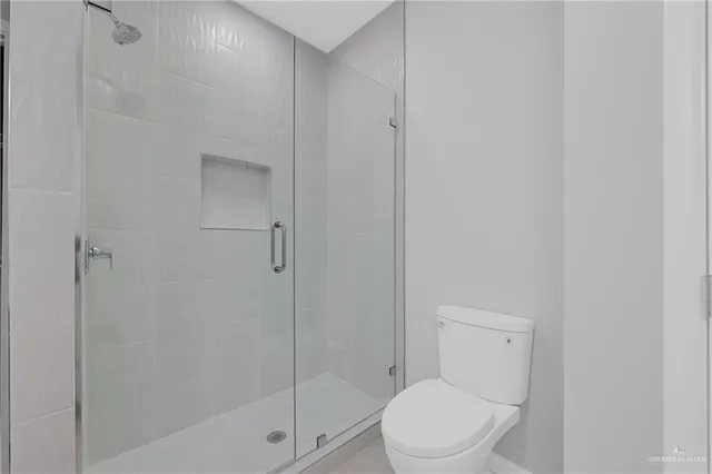 a white toilet next to a bathroom