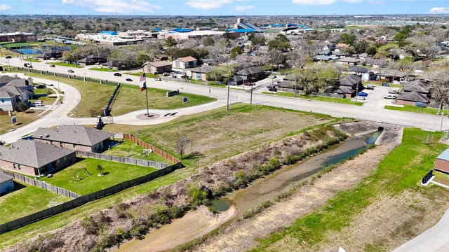 an aerial view of a swimming pool with a yard and lake view