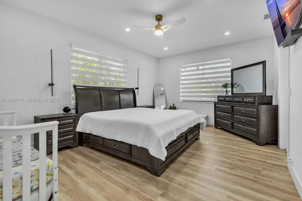 a spacious bedroom with a bed and a chandelier