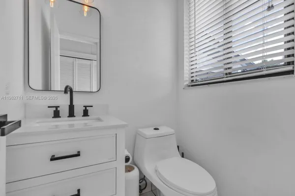 a bathroom with a toilet a sink and a mirror
