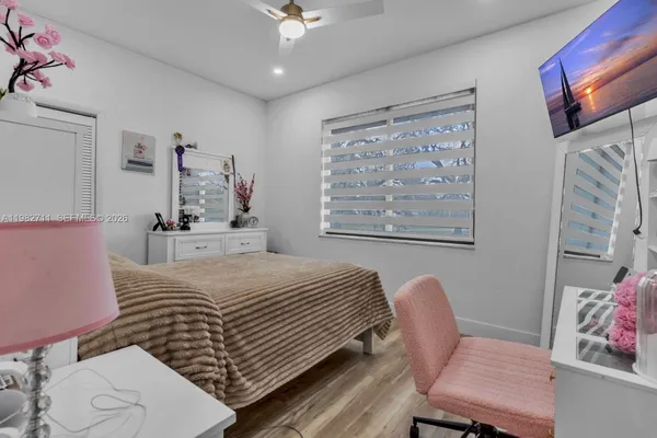 a kitchen with a stove a sink dishwasher a refrigerator with white cabinets and wooden floor