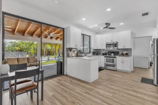 a kitchen with kitchen island a white counter top space cabinets and stainless steel appliances