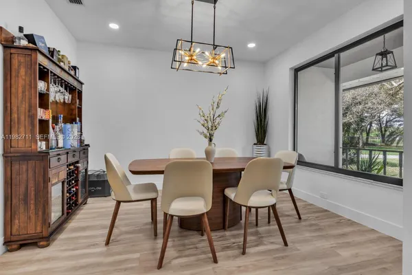 a dining room with furniture a chandelier and wooden floor
