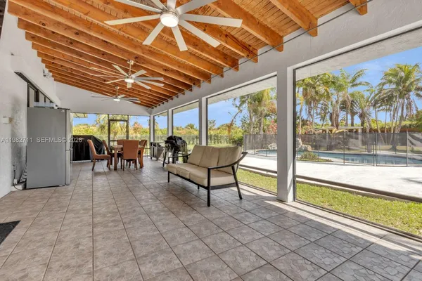 a dining area with furniture and a floor to ceiling window