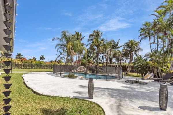 an aerial view of a house with a yard and large trees