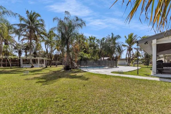 a view of a house with potted plants and a table and chairs
