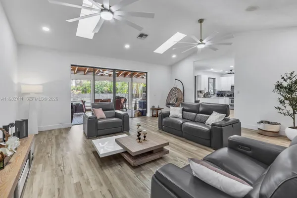 a living room with furniture a chandelier and a flat screen tv