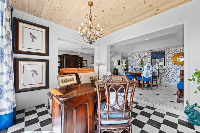 a view of a dining room with furniture a chandelier and wooden floor