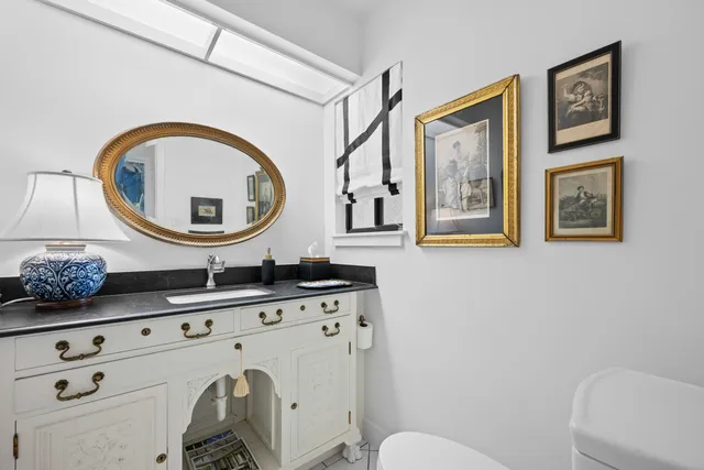 a bathroom with a toilet a sink and a mirror