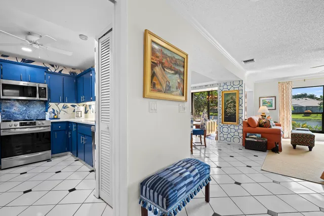 a kitchen with stainless steel appliances kitchen island granite countertop a refrigerator a stove a sink a dining table and chairs with wooden floor