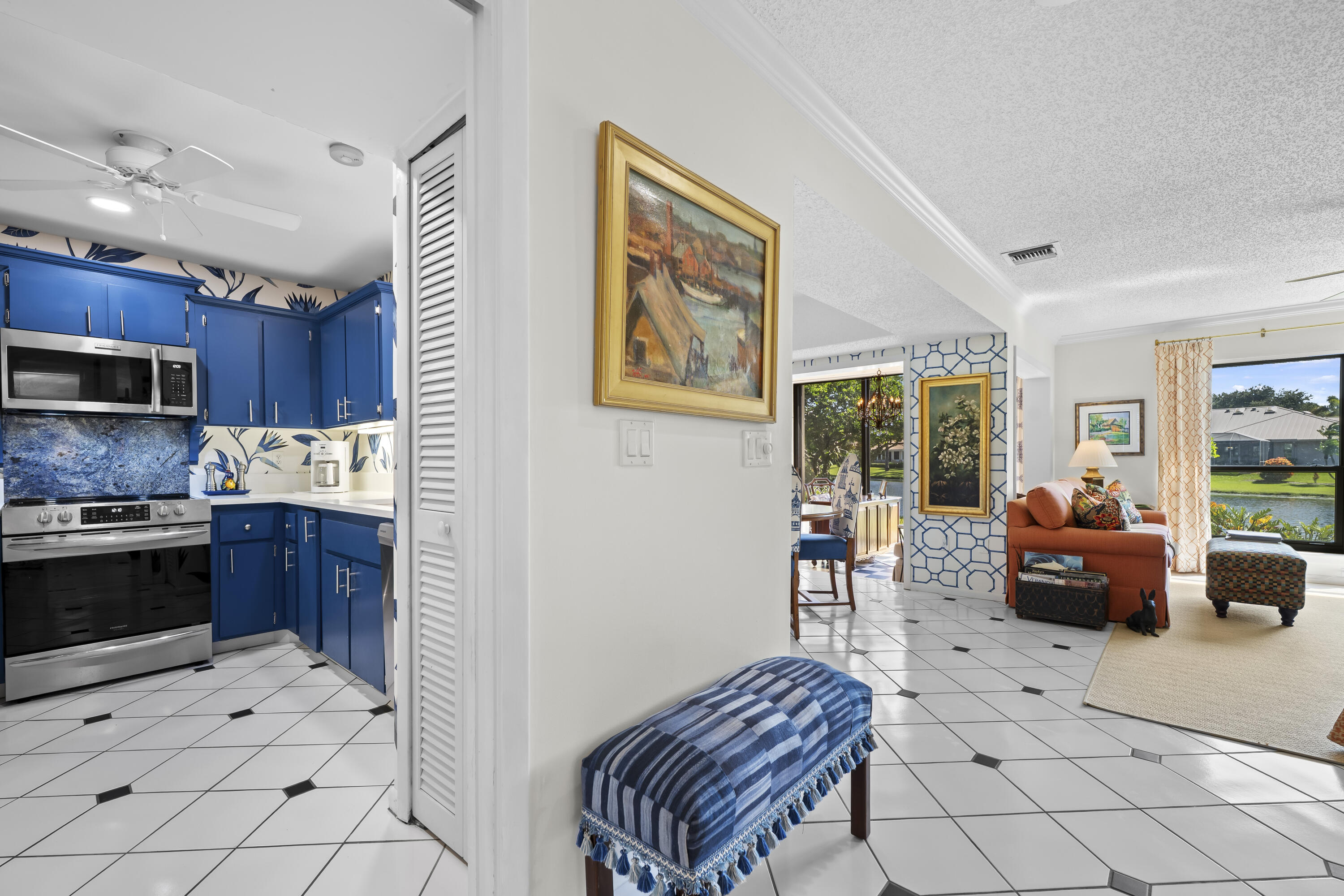 5610 Southeast Foxcross Place Stuart, FL 34997 - Photo 4 of 39 a kitchen with stainless steel appliances kitchen island granite countertop a refrigerator a stove a sink a dining table and chairs with wooden floor