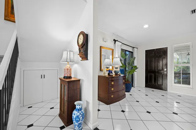 a living room with furniture a flat screen tv and a refrigerator