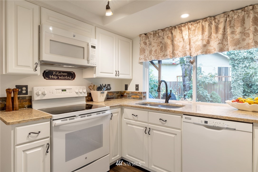 2603 177th Street Southeast Bothell, WA 98012 - Photo 2 of 25 a kitchen with white cabinets and white appliances