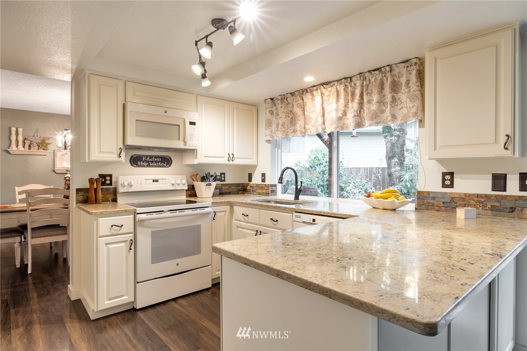 2603 177th Street Southeast Bothell, WA 98012 - Photo 5 of 25 a kitchen with stainless steel appliances granite countertop a sink a stove and cabinets
