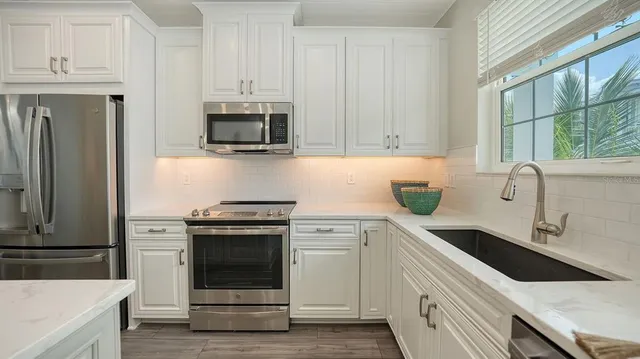 a kitchen with stainless steel appliances white cabinets and a sink