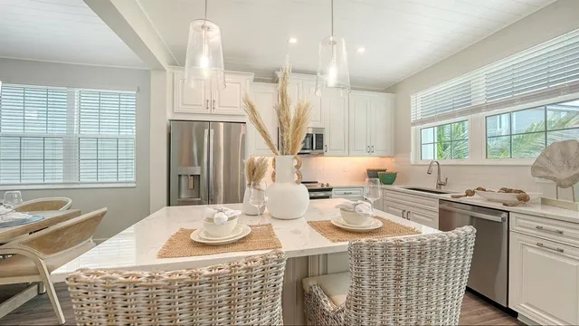 a kitchen with stainless steel appliances granite countertop a stove a kitchen island a dining table and chairs